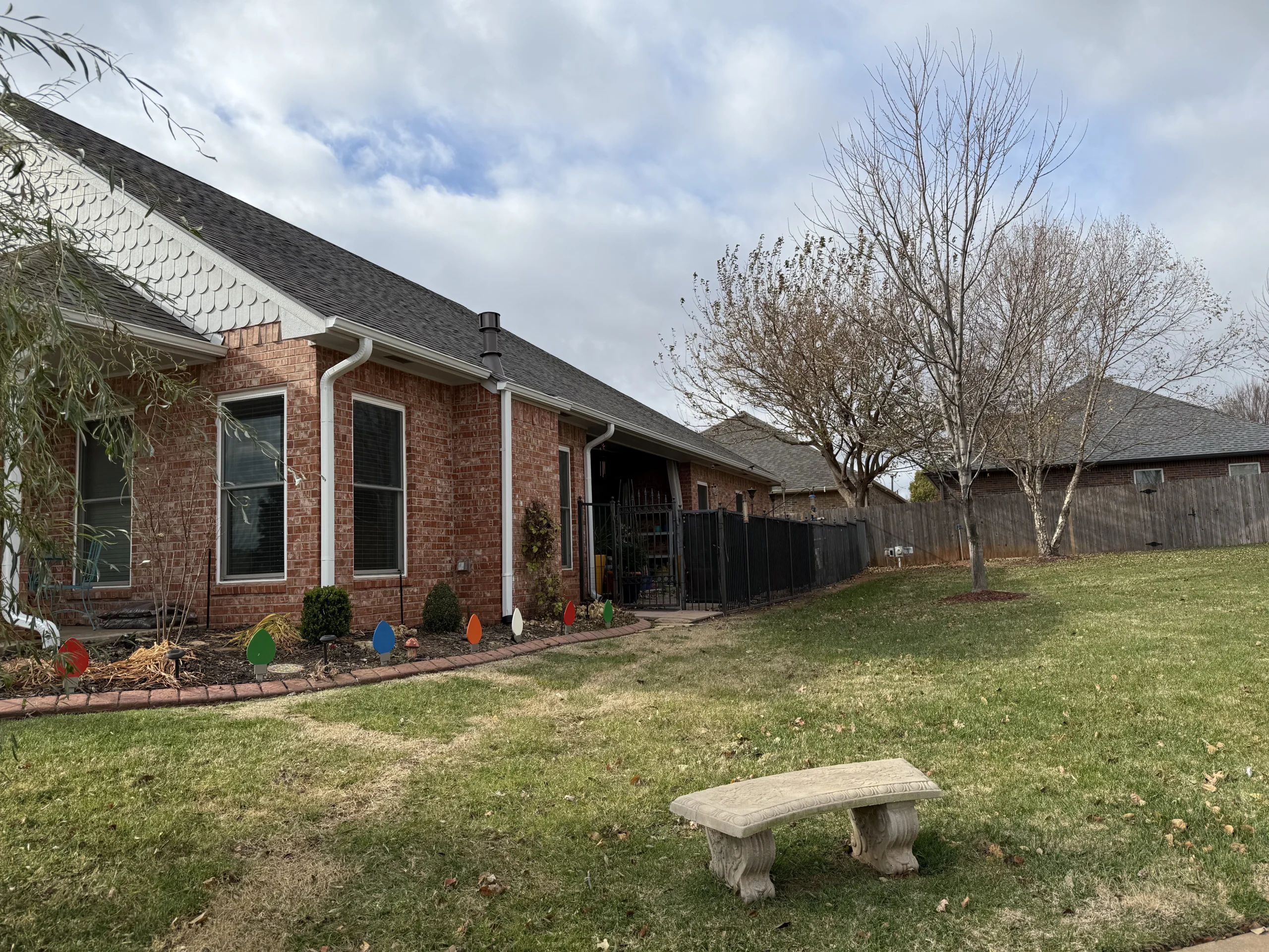 side view of a red bricked home with recently installed customer white gutters