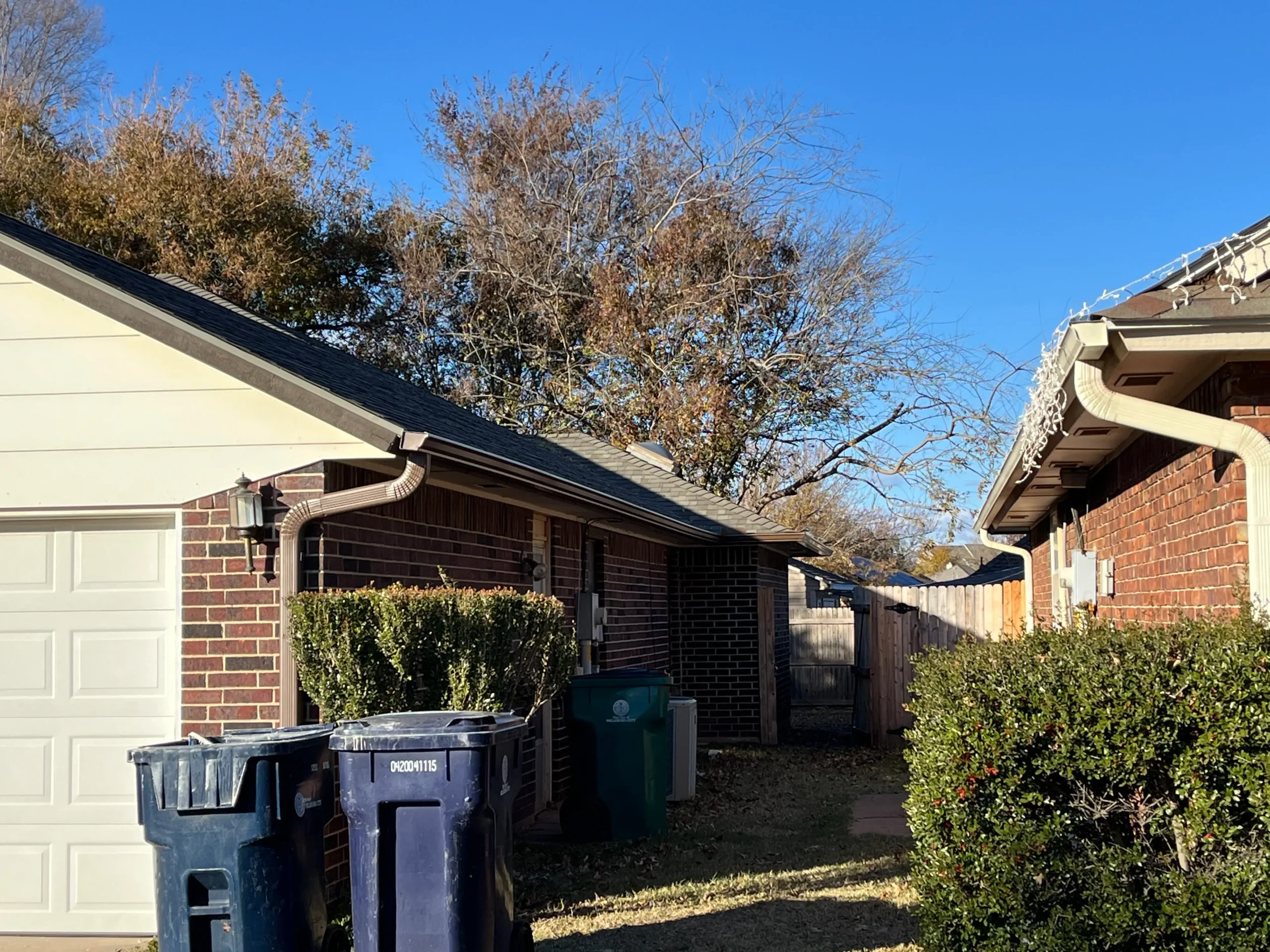 the side of a dark bricked home recently upgraded with customer gutters