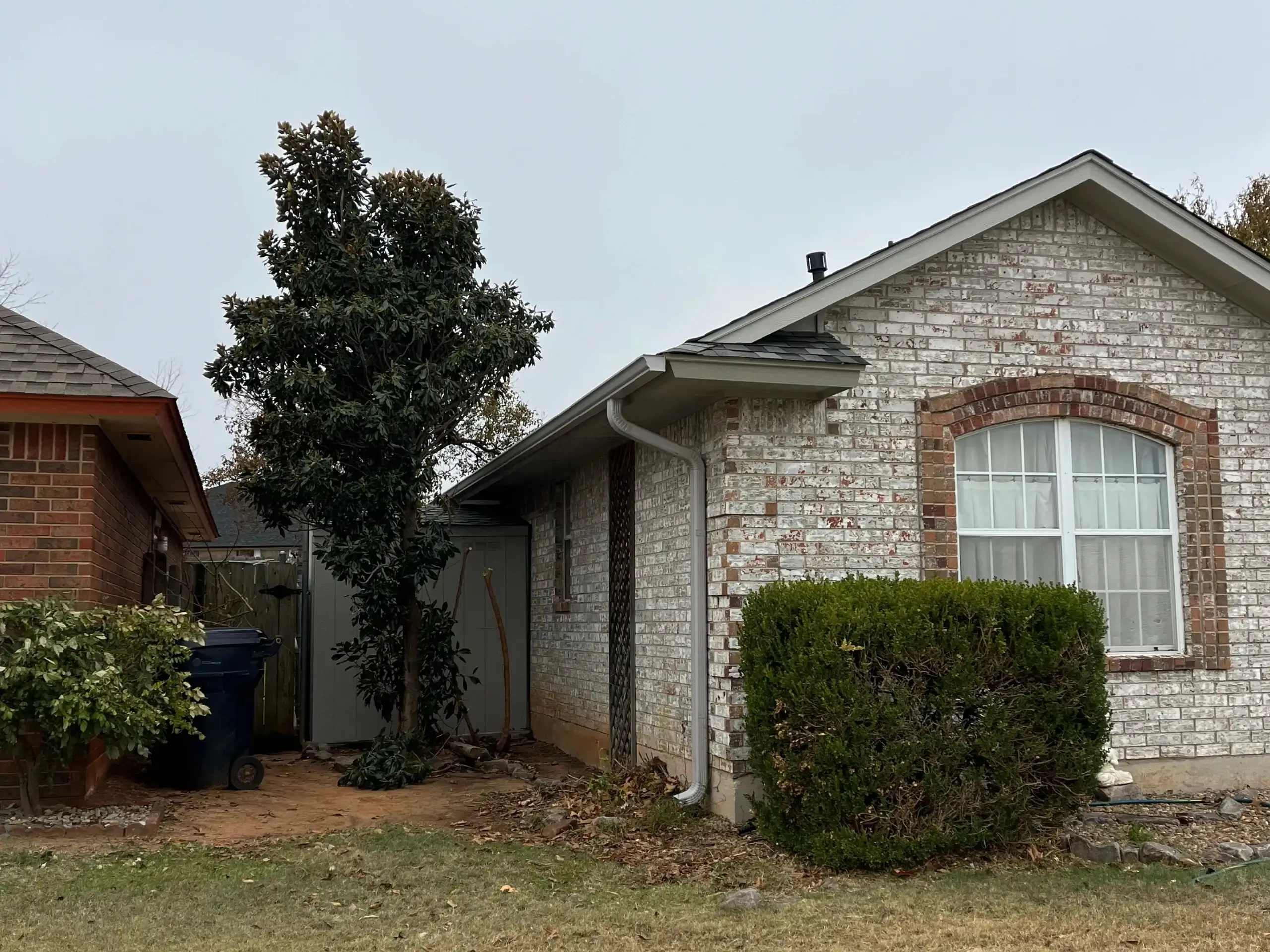 front view of a light gray stone home recently upgraded with custom gutters