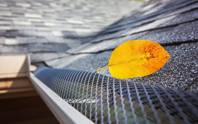 800x450 wire rain gutter guards with a yellow leaf installed along a roof line